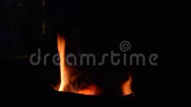 自然的火焰从火中冒出来，橙色的火焰在夜晚的空地上，木柴慢慢燃烧和燃烧，乡村的生活