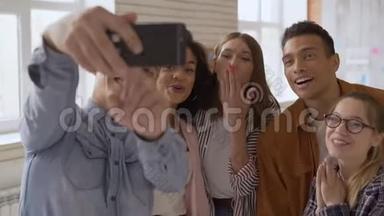 混合种族组5人.. 喜欢在手机摄像头上说话的人。 青少年们笑着向摄像机问好