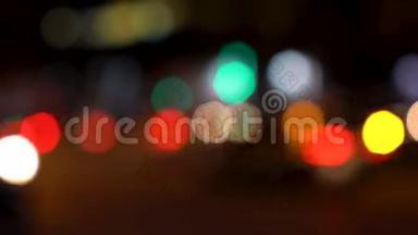 夜间在城市街道上的汽车、滑板车、摩托车和交通工具的散焦或软焦灯光
