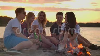 年轻人正在沙滩上享受温暖的夏日夜晚