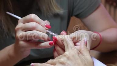 美甲大师用刷子在客户的食指指甲上创建一个梯度。