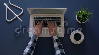 穿灰色衬衫的<strong>创意</strong>女孩<strong>正</strong>坐在桌子旁喝咖啡时，在笔记本电脑上打字。 就在附近