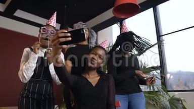 漂亮的四个非洲女孩在生日聚会上<strong>拍照</strong>时，在智能手机摄像头上摆<strong>姿势</strong>。