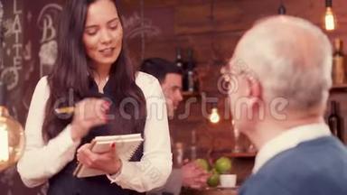 一位漂亮的女服务员从戴眼镜的老人那里点餐