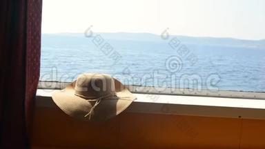 渡船舱窗上草帽.. 暑期旅游概念。 假日
