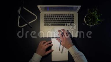 一个男<strong>人坐</strong>在桌子旁，晚上<strong>坐</strong>在笔记本<strong>电脑前</strong>，在笔记本上画一张收入图。 4k