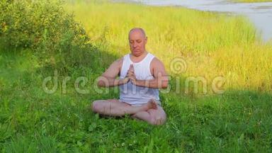 一位中年男子早上在湖上做呼吸瑜伽和冥想