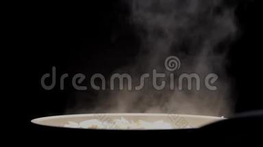 在黑色背景的餐厅厨房里用白色厚蒸汽煎锅。 烹饪鸡肉