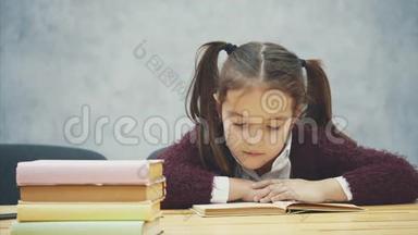 一个女<strong>学生</strong>坐在灰色背景上。 在这段时间里，小<strong>学生</strong>仔细阅读这本书。 勤奋的<strong>学生</strong>