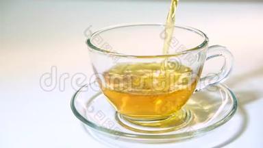 在白色<strong>背景</strong>特写镜头上，将茶壶中的<strong>红茶</strong>香气注入一个匹配的透明玻璃茶杯。