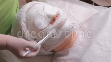 美容师的手在女人的脸上涂<strong>上海</strong>藻酸钠的毛孔，缩<strong>小</strong>面具。 皮肤清洁和恢复活力。 医疗