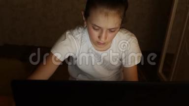疲惫的少女看着笔记本显示器的屏幕。 特写镜头。 1.一个年轻女孩看电脑屏幕<strong>很累</strong>