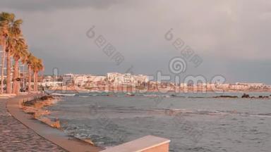 帕福斯码头。 塞浦路斯的旅游长廊。 粉红色黄昏的旅游区。 有吸引力的男跑运动员沿着岩石海滩训练。 地中海