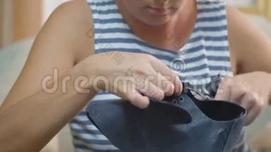 鞋匠的双手`她的女人沿着皮鞋的轮廓剪开