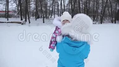 妈妈双手抱着小宝宝走在冬天的雪道上。 女儿在妈妈手里笑。 家长服务