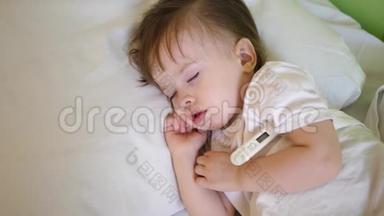 有<strong>体温计</strong>的生病孩子睡在白床上。 在医院病房用温度计测量儿童的体温