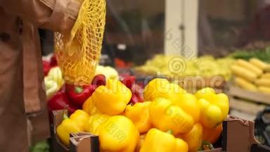 女人在超市买水果，黄色美丽的木瓜。 她把蔬菜放在可重复使用的袋子里。 生态包装