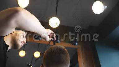 多莉拍摄的男理发师梳理他的客户头发在时尚理发店。 年轻人的后视图