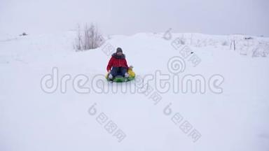 快乐的女孩骑着高高的雪山雪碟，笑。 孩子在冬天雪橇，微笑着。 山区度假胜地
