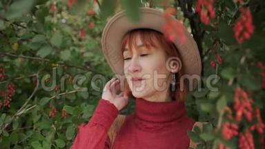 一个年轻迷人的红发女孩，一头短发戴着帽子，在一个自然公园里穿着一件兵马俑毛衣。