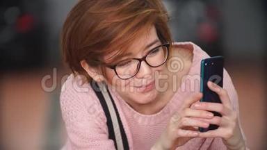 一位漂亮的红发女孩在一位智能手机技工身上拍照