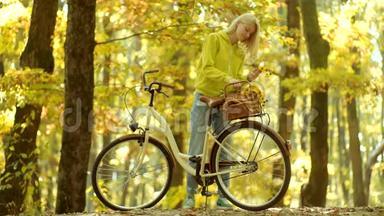 女孩们抱着带花篮的旧自行车车把。 公园里骑自行车的漂亮年轻女人。 无忧无虑的女人。 秋天