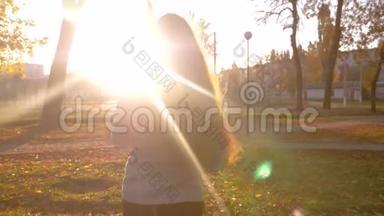 美丽的独立女孩，长发，带着小婴儿的手在<strong>公园里散步</strong>，在夕阳的照耀下。 保姆