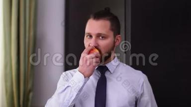 留胡子的男人的肖像，现<strong>代发</strong>型，咬着嘴嚼着苹果，看着镜头