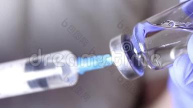 医生`他的手把注射器装满疫苗，为注射给病人做准备。