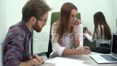 年轻漂亮的女人在电脑上给她的同事看一个项目，他们讨论商业战略或计划。 <strong>创意创意</strong>