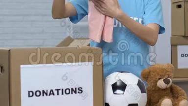 女义工在捐款箱内包装儿童物品，帮助孤儿回家