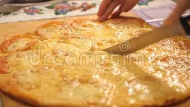 特写镜头：一个人用披萨刀把一个意大利香肠披萨切成多片