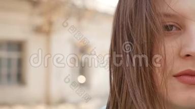 一位年轻女子站在风中的特写肖像。 春风吹着女孩`头发。 慢动作