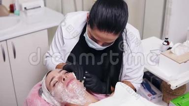 专业的美容师在面膜做多次注射在妇女`脸颊在中间治疗。 生物重组和