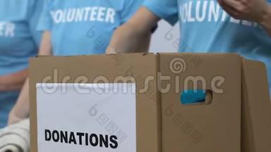 志愿者把衣服装在盒子里接受捐赠，低收入家庭援助