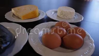 高蛋白食物。 生肉和鱼，奶酪，鸡蛋在单独的盘子里。 摄像机绕着这个向左移动