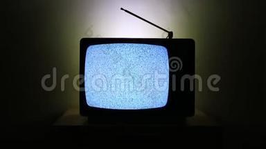一台老式电视的视频，在黑暗的背景上被隔离，屏幕上没有信号和灰度噪<strong>声</strong>的影响