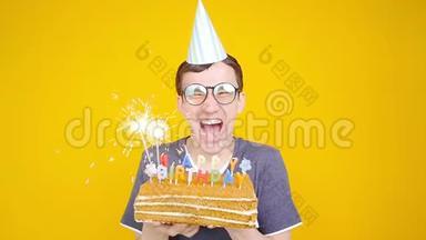 生日快乐。 带着橙色背景蛋糕的年轻滑稽男子