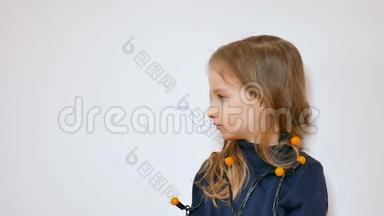 一张可爱的小女孩的冬季画像，她留着长长的金发和蓝色的大眼睛，戴着一束黄色的圣诞灯