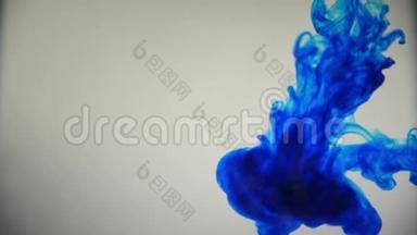 蓝色油漆墨水倒在玻璃上，墨水滴落和抽象烟雾爆炸。