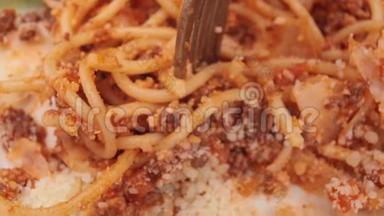 用叉子将新鲜意大利面条与番茄酱配在一起，做成美味可口的意大利面条