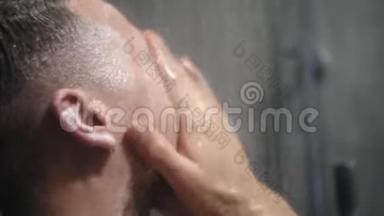 年轻的金发男人正在洗澡。 用热<strong>水</strong>和洗发<strong>水</strong>洗头。 关门
