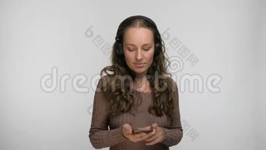 高兴的女人听着她最喜欢的一首关于智能手机<strong>跳舞和唱歌</strong>的歌，一边欣赏音乐的肖像。