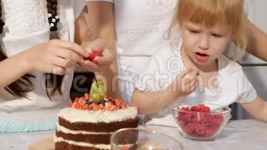 <strong>一家人</strong>，妈妈带着两个小女儿在家里的厨房里<strong>一起</strong>装饰生日蛋糕和浆果。