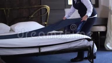 <strong>酒店</strong>清洁工在一间舒适的小旅馆房间里铺一张<strong>双人床</strong>。 慢动作。