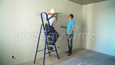 施工现场两名工人在<strong>墙上贴</strong>墙纸