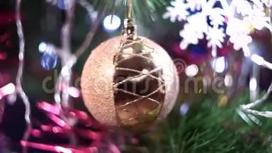 一个<strong>透明</strong>的大圣诞树球，上面满是<strong>金色</strong>的金卷筒，在绿色的树枝间旋转，近景