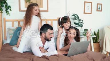爸爸，妈妈和两个女儿在笔记本<strong>电脑</strong>上<strong>玩电脑</strong>游戏，慢动作