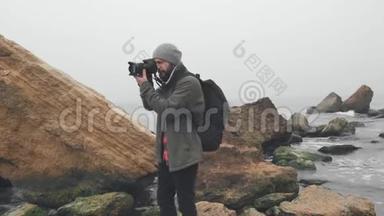 年轻摄影师用数码<strong>单反相机</strong>拍摄海洋悬崖