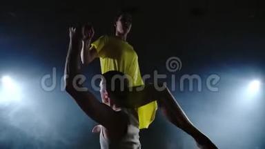 变焦相机，一个<strong>女舞者</strong>跳到她的搭档肩膀上。 舞台上的杂技舞蹈音乐剧。 当代